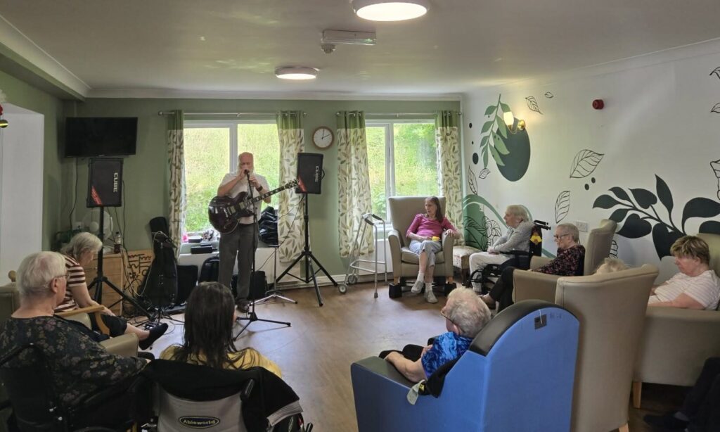 Resident enjoying a Father's Day party in the lounge at Abbeywell Court