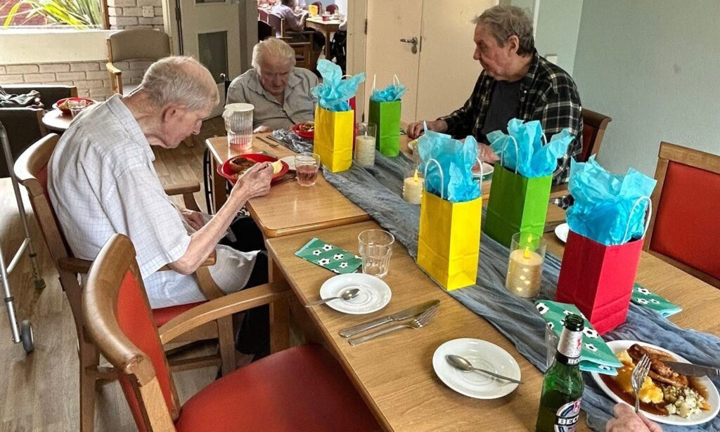 Residents receiving small gifts during a traditional Sunday dinner on Father's Day at Crossways